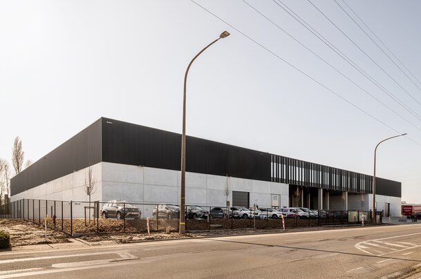 Langgerekt bedrijfsgebouw met metalen gevelbekleding en betonstructuur langs de straat in Oudenaarde | © Michiel Vergauwe