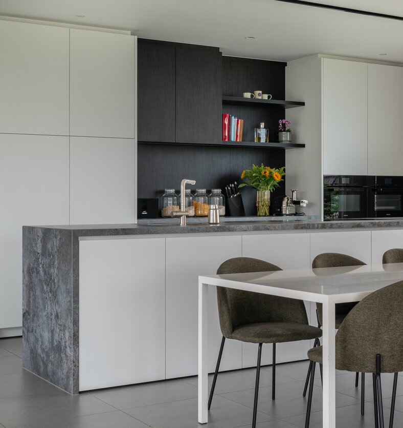 Minimalistische leefkeuken met kookeiland, maatwerk en een strak hedendaags interieur.